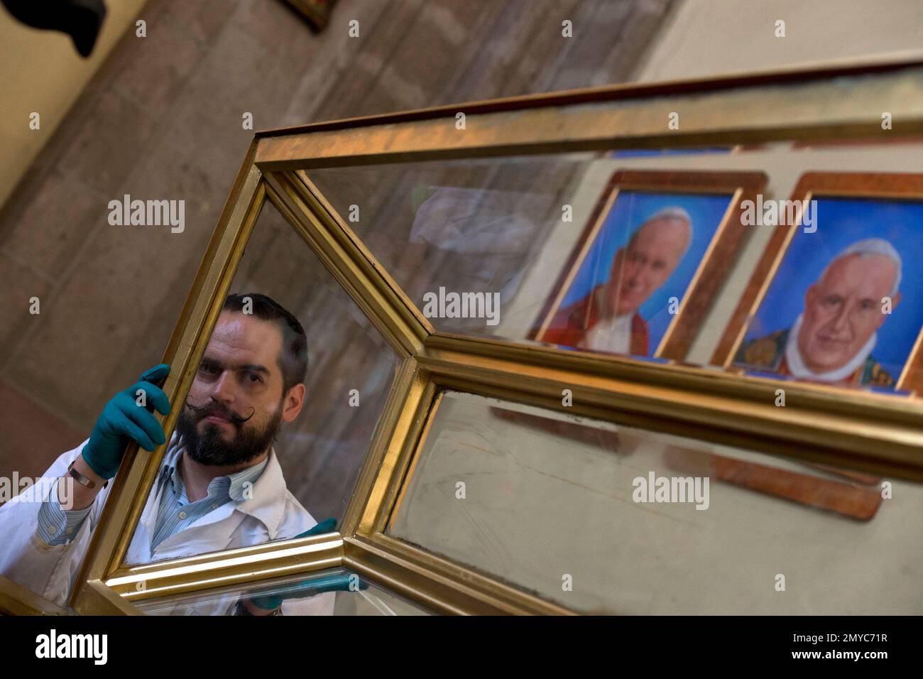 Restoration worker Gerardo Villarreal Zermeno holds up the lid of a