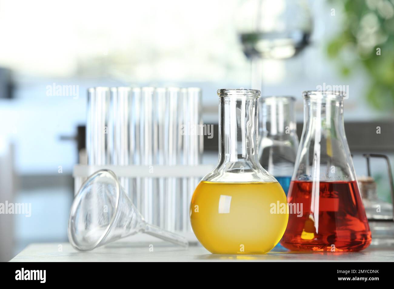 Laboratory glassware with different liquid samples on table Stock Photo ...