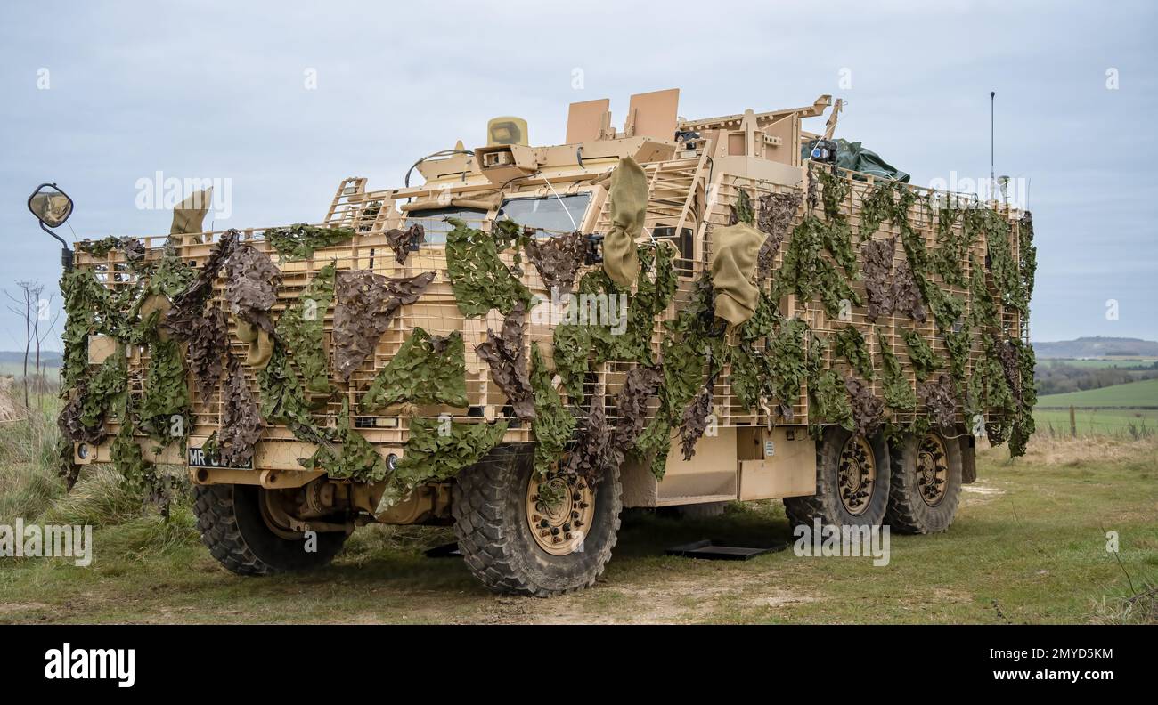 close-up of a British army Mastiff protected patrol vehicle under green camouflage netting Stock Photo