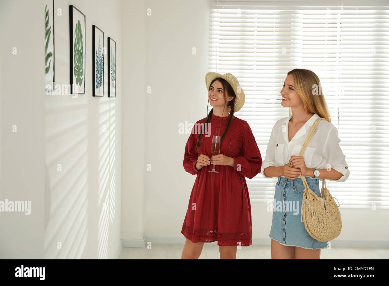 Young women at exhibition in art gallery Stock Photo - Alamy