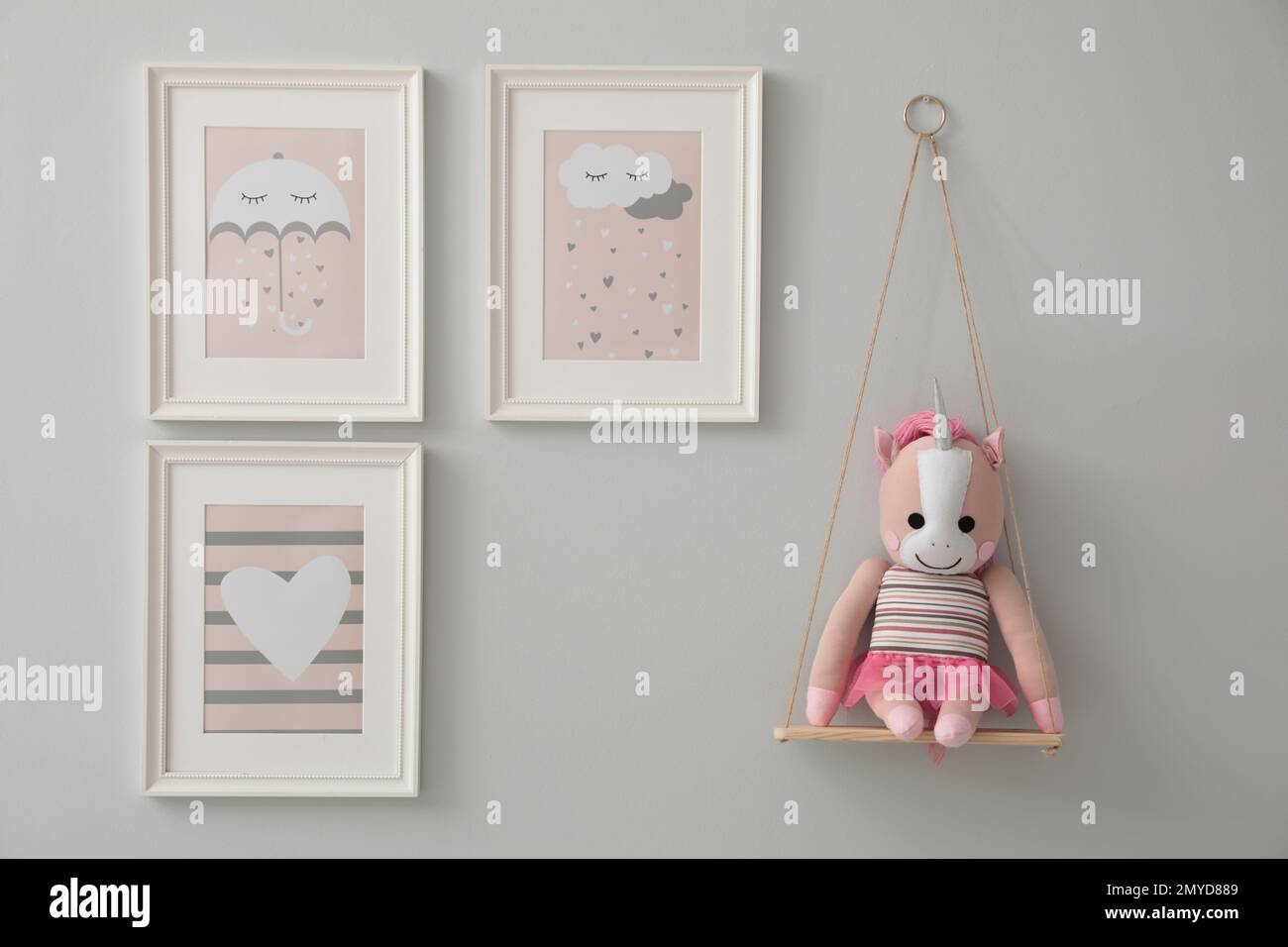 Different cute pictures on grey wall. Baby room interior Stock Photo