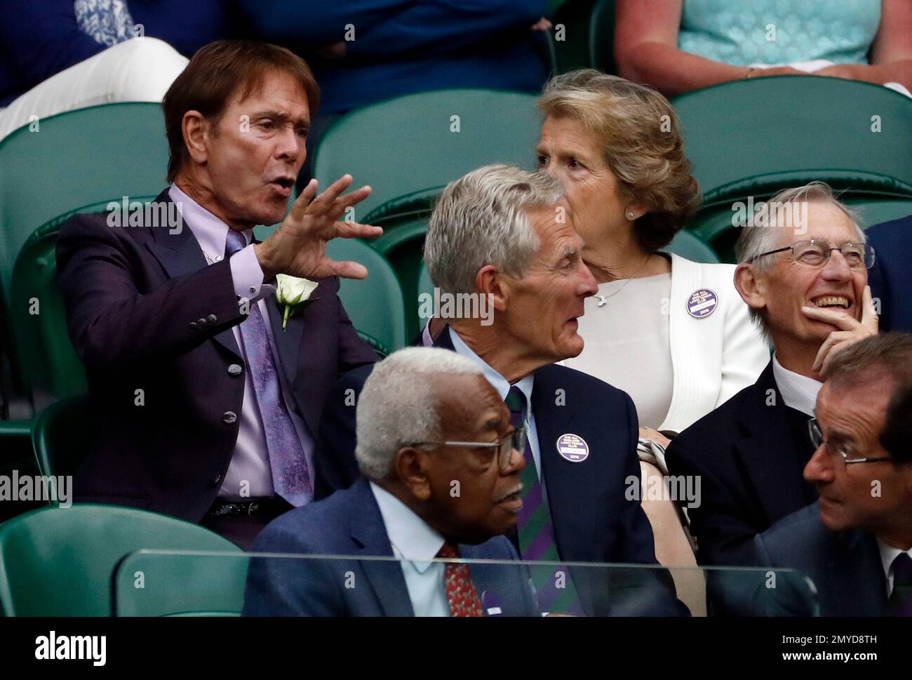 Singer Sir Cliff Richard, left, and former news reader Sir Trevor McDonald, front centre, sit in the Royal Box during day five of the Wimbledon Tennis Championships in London, Friday, July 1, 2016. (AP Photo/Ben Curtis) Stock Photo