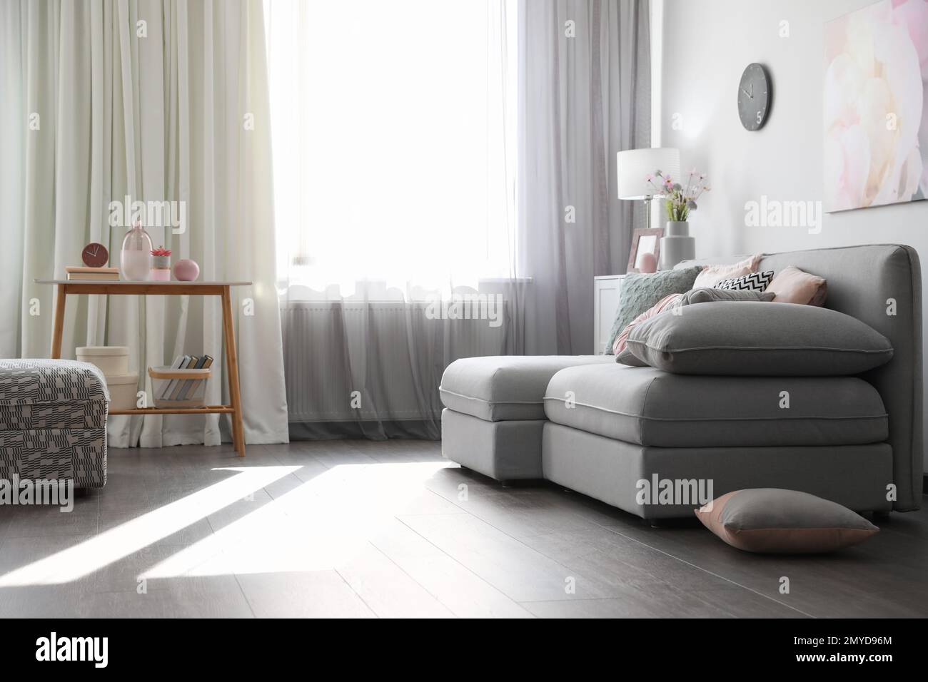 Elegant living room with comfortable sofa near window. Interior design