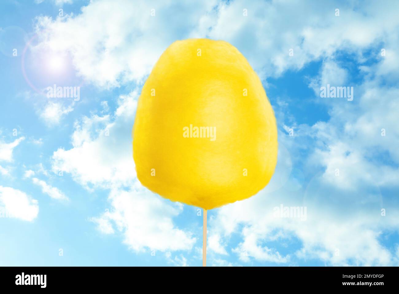 Yellow cotton candy against blue sky with clouds Stock Photo Alamy