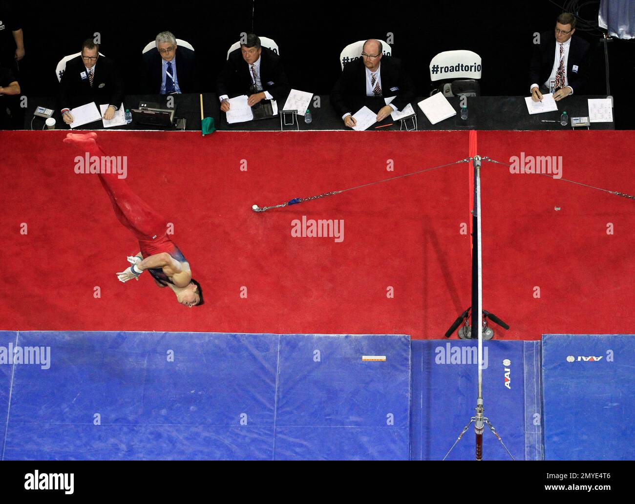 Judges watch as Chris Brooks dismounts the parallel bars during the U.S