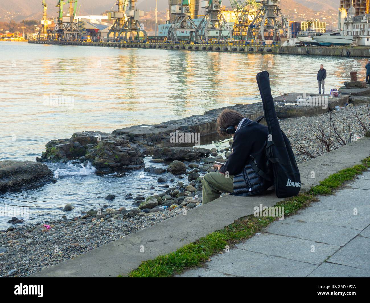 Batumi, Georgia. 01.21.2023 A guy with a guitar in a case is sitting on ...