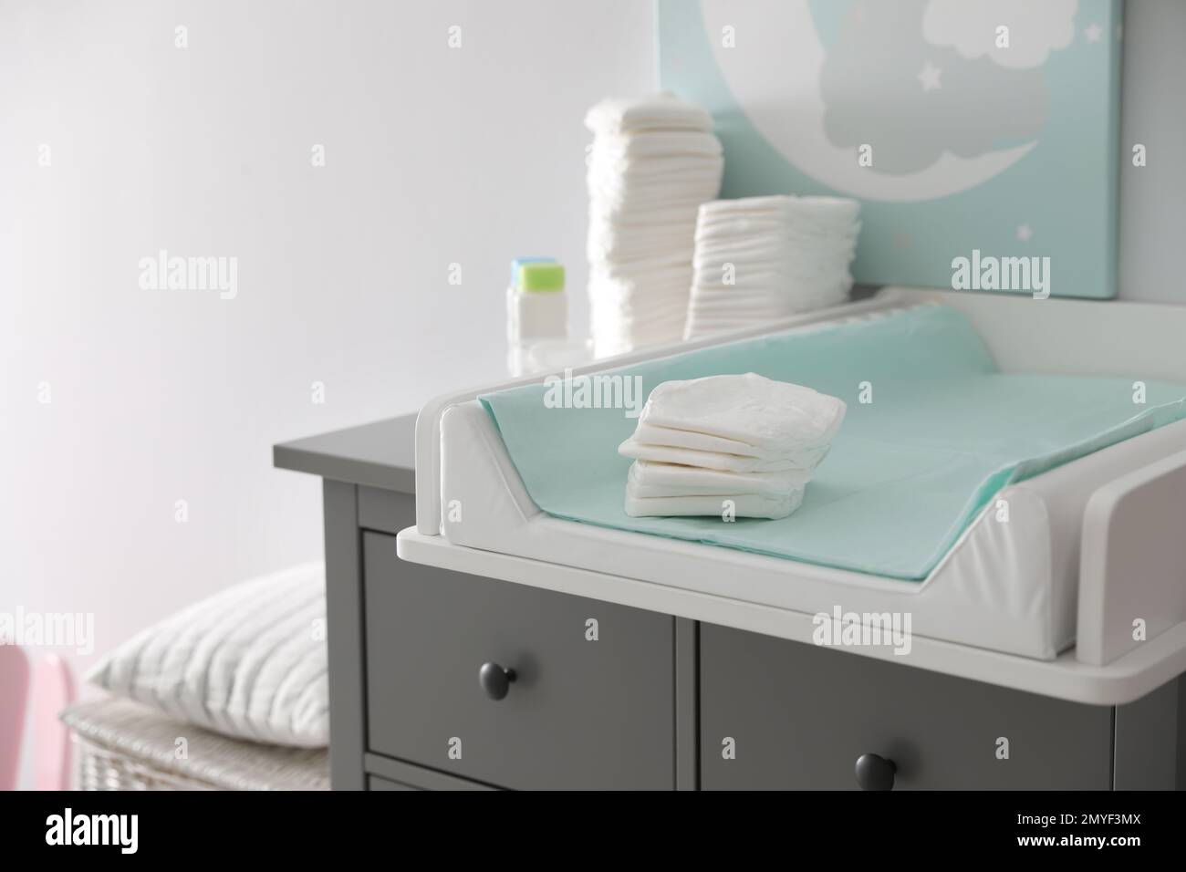 Chest of drawers with changing tray and pad in baby room. Interior