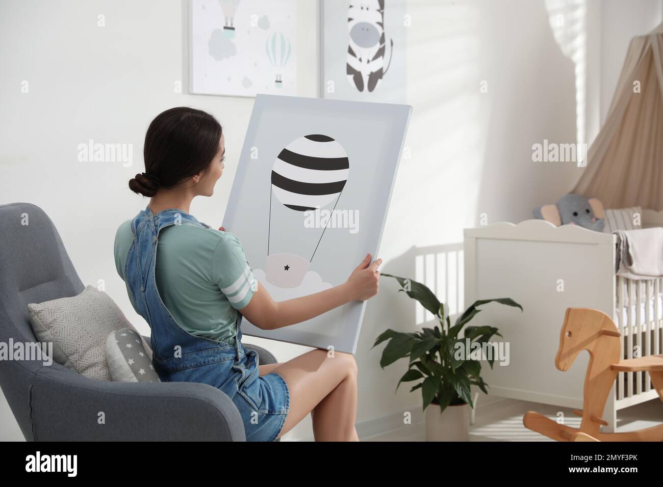 Decorator with picture sitting indoors. Children's room interior design Stock Photo Alamy