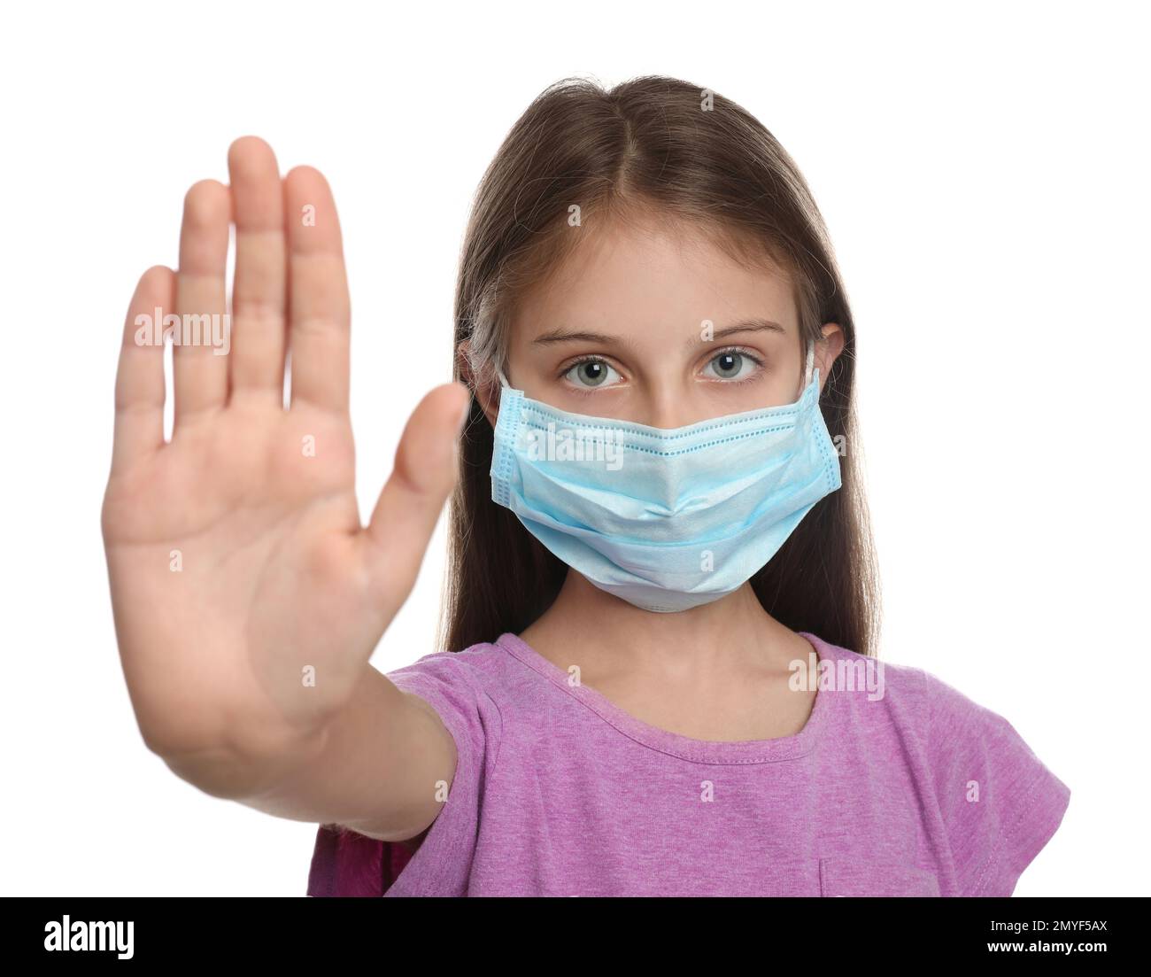 Little girl in protective mask showing stop gesture on white background ...