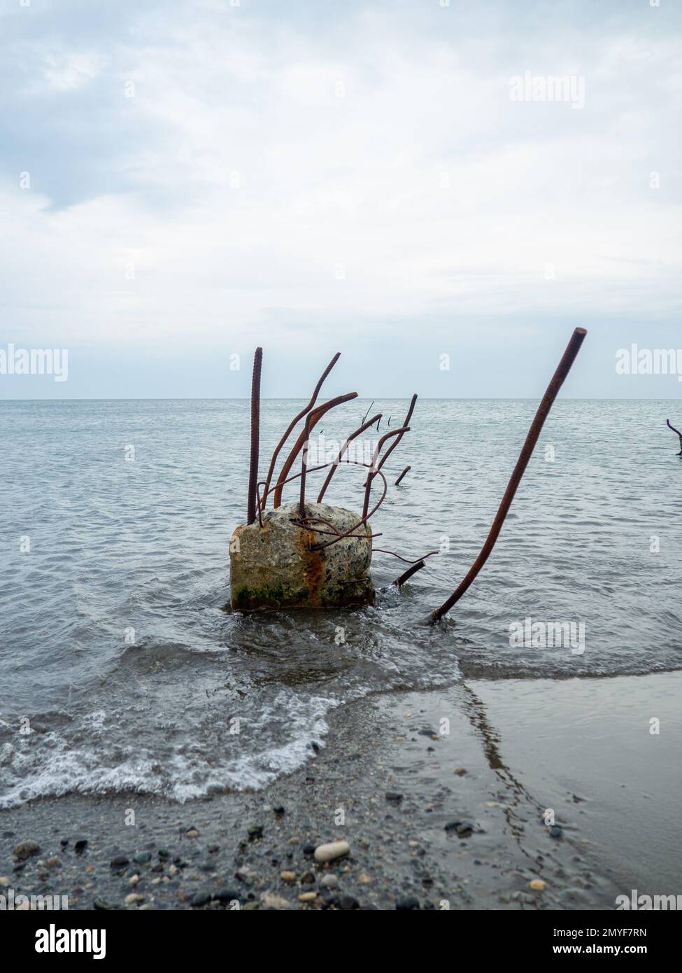 Reinforced concrete sticking out of the water. Remains of the structure