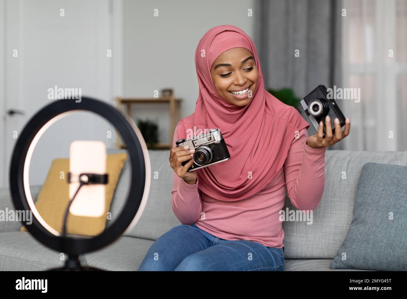 Excited black muslim lady shooting video for blog, making review on ...
