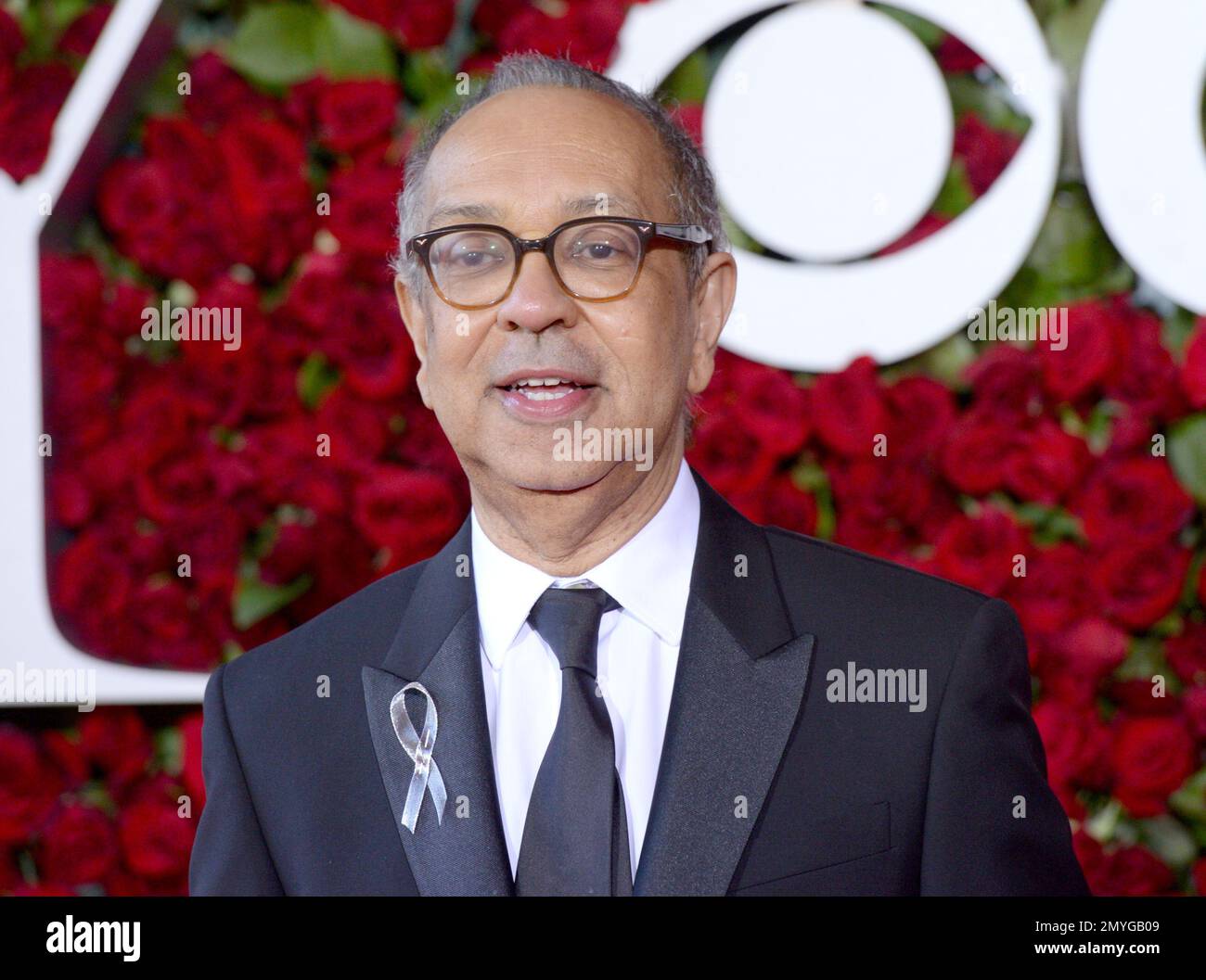 George C. Wolfe wears a silver ribbon as he arrives at the Tony Awards ...
