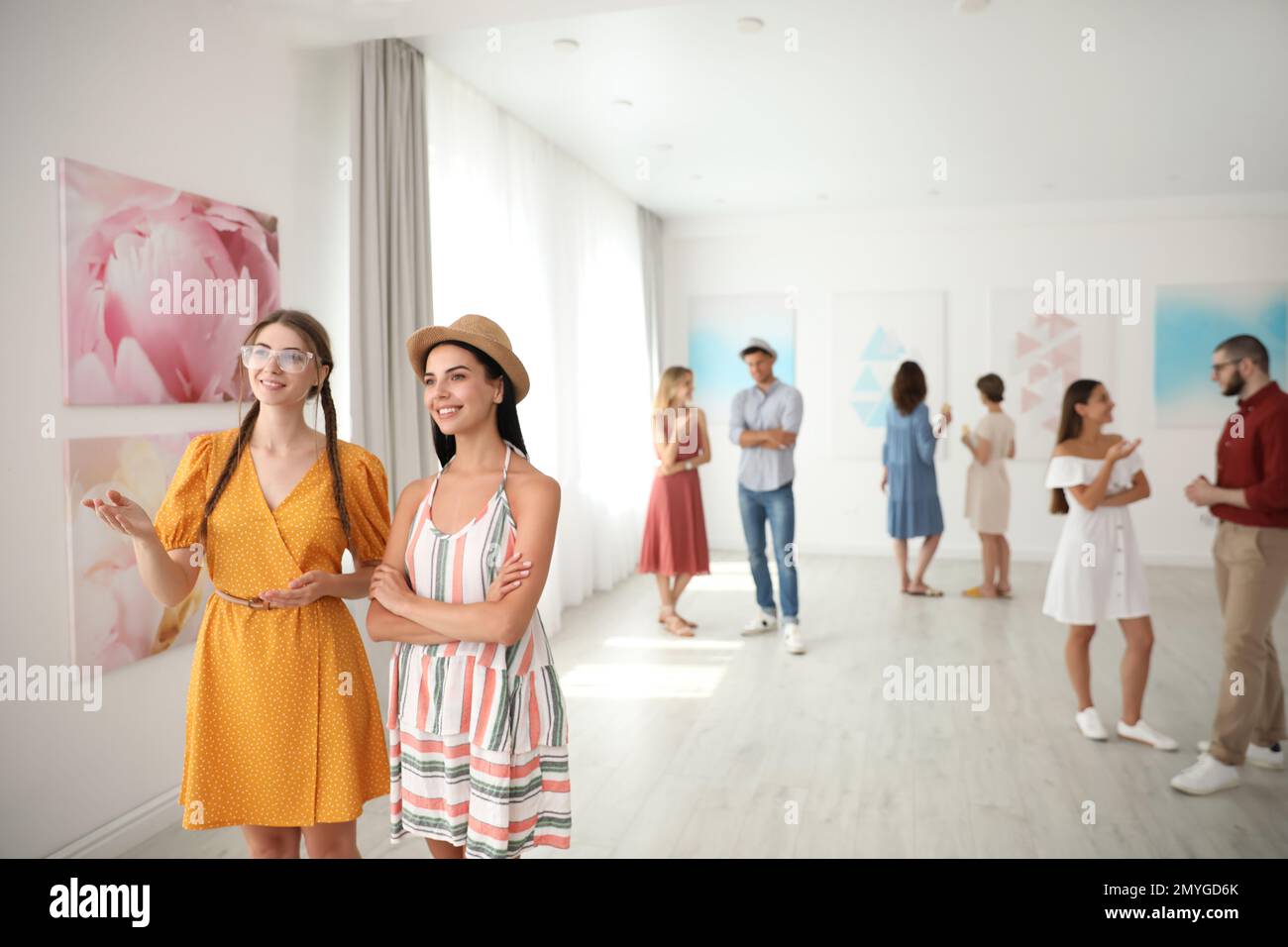 Young women at exhibition in art gallery Stock Photo - Alamy