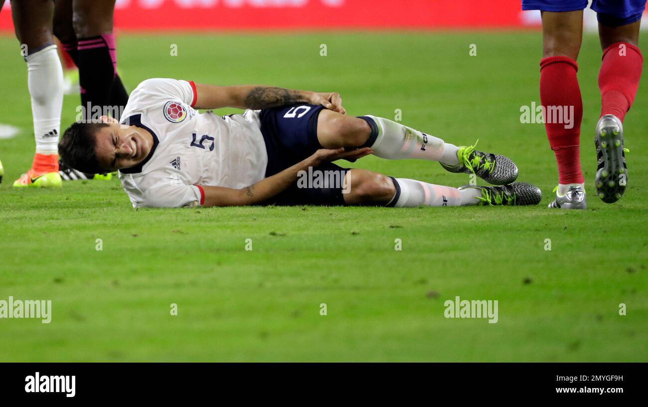 Colombia's Guillermo Celis (5) holds his leg after he collided with a