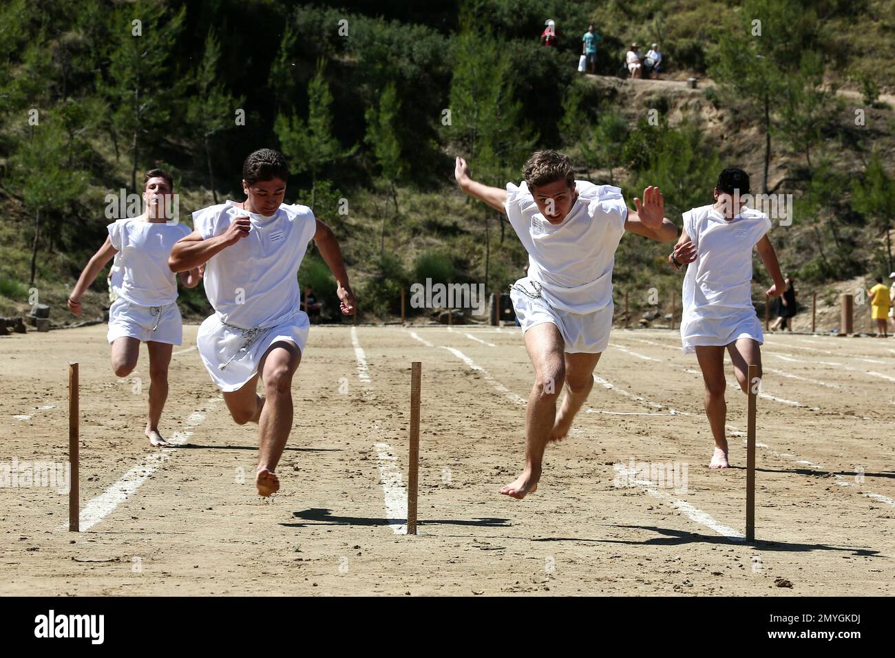 Barefoot runners wearing tunics take part in a footrace in the ancient ...