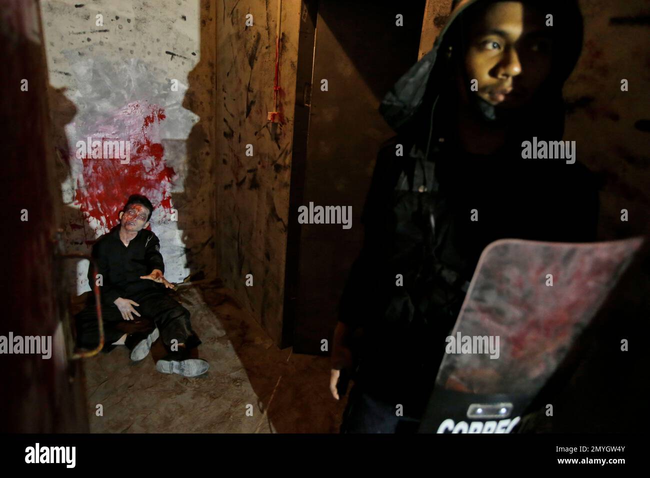 An actor, dressed as zombie, sits on the floor during a media tour at