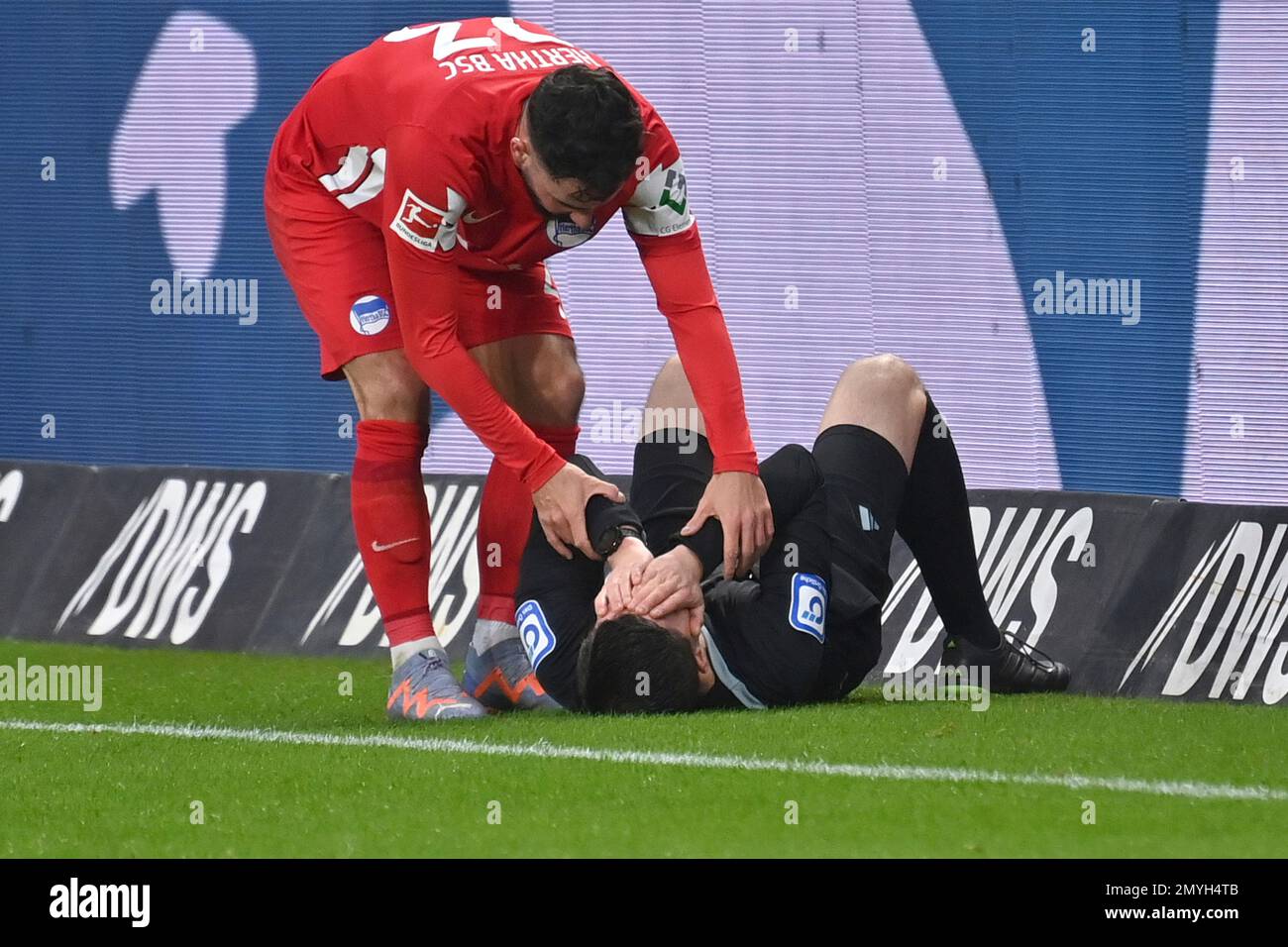 linesman Stefan Lupp lies dazed on the ground after being hit in the face by the ball. Marco RICHTER (Hertha BSC) provides assistance. Football 1st Bundesliga season 2022/2023, 19th matchday, matchday19, Eintracht Frankfurt - Hertha BSC 3-0, on February 4th, 2023, DEUTSCHE BANK PARK Frankfurt. ? Stock Photo