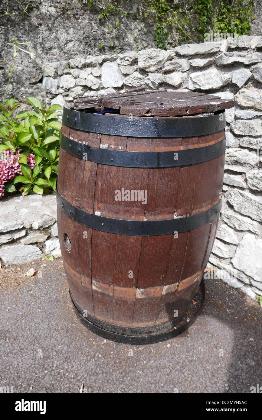 Old weathered beer or whiskey barrel outside on sunny day Stock Photo