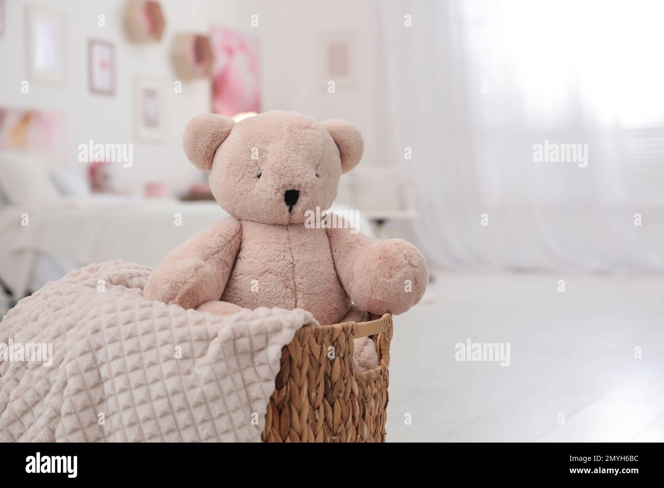 Cute teddy bear and blanket in wicker basket indoors Stock Photo Alamy