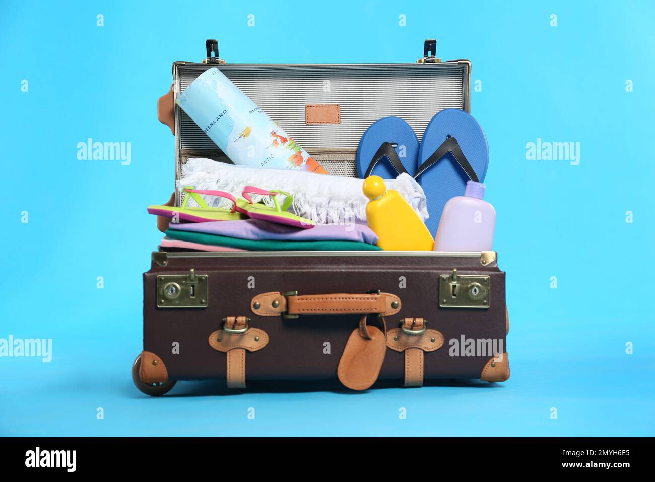 Open vintage suitcase with different beach objects packed for summer ...