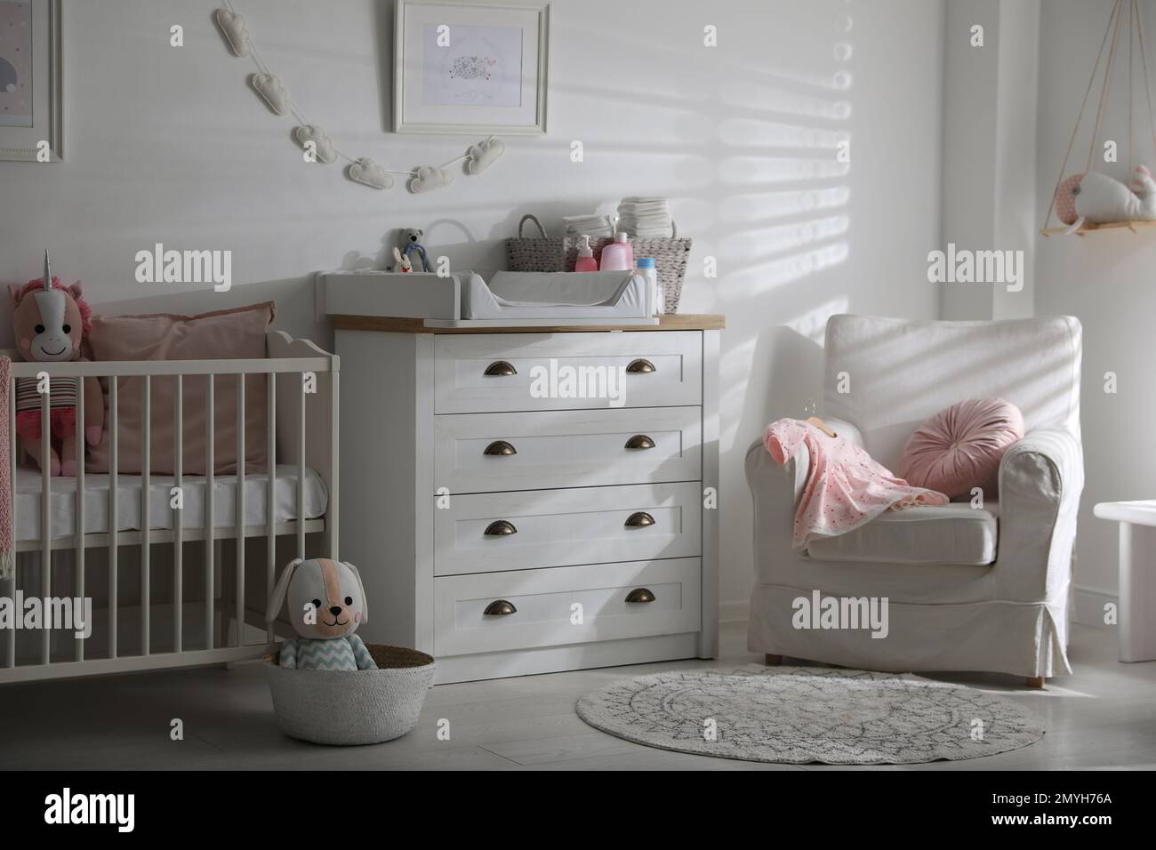 Chest of drawers with changing tray and pad in baby room. Interior