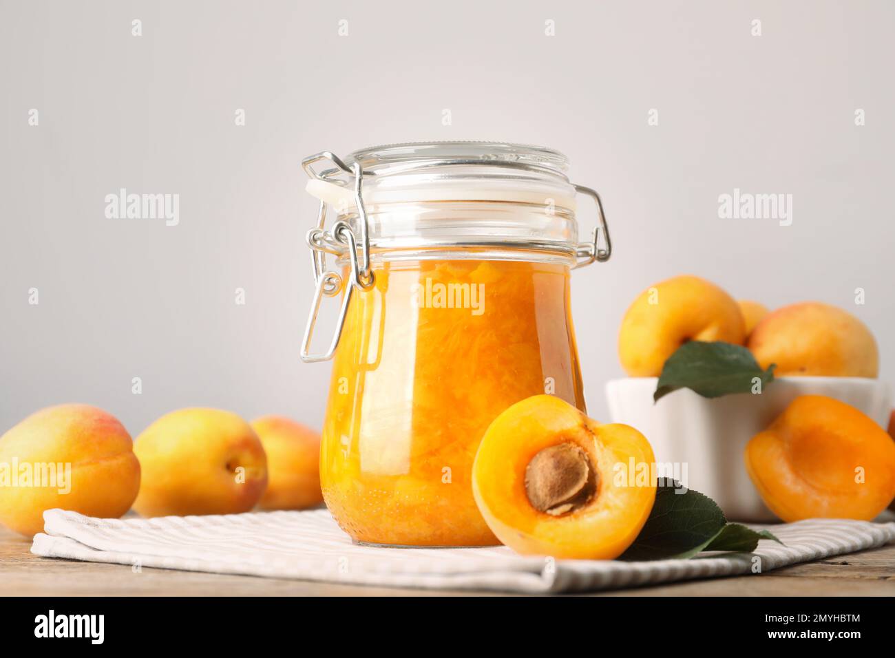 Jar of apricot jam and fresh fruits on table Stock Photo