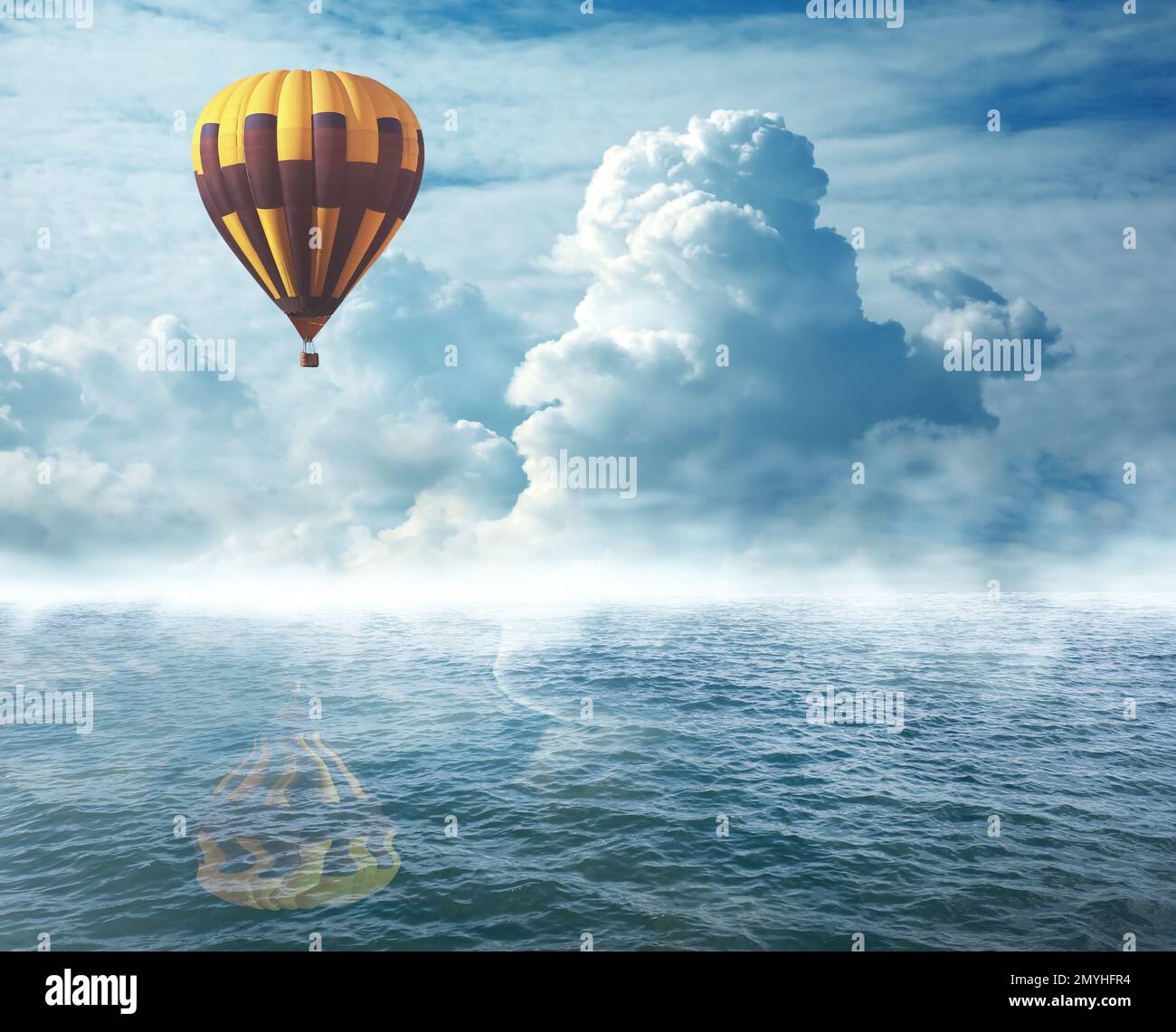 Dream world. Hot air balloon in cloudy sky over misty sea Stock Photo ...