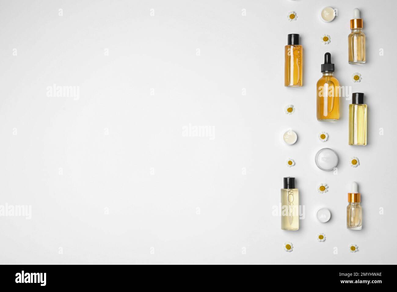 Flat lay composition with chamomiles and cosmetic products on white ...