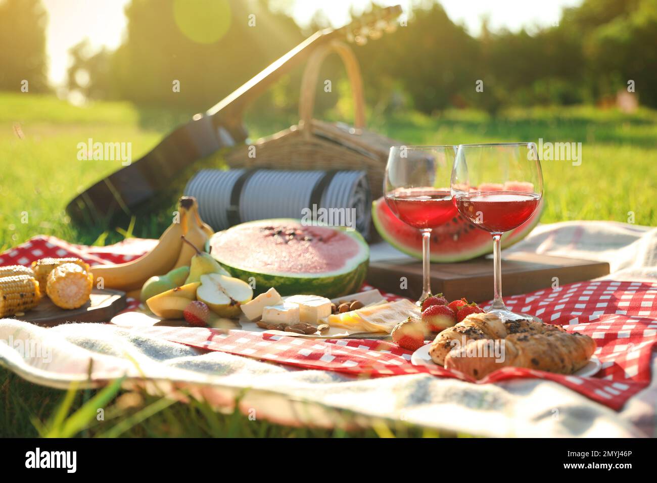 Picnic blanket with delicious food and drinks outdoors on sunny day ...