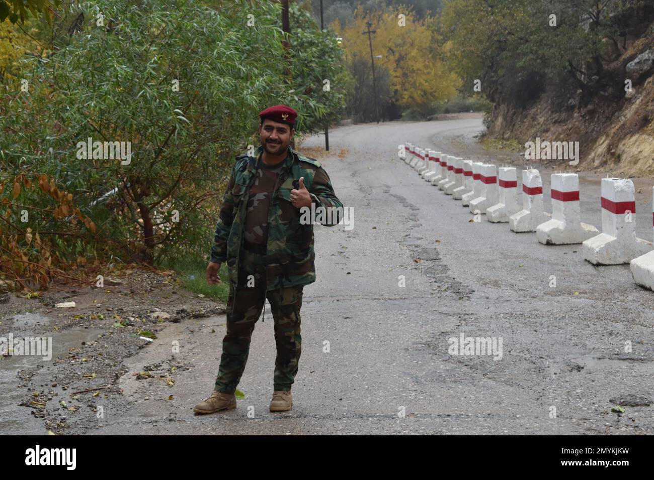 A smiling soldier of the Kurdish military welcomes guests to Lalish, the holiest site of the Yazidi religion Stock Photo