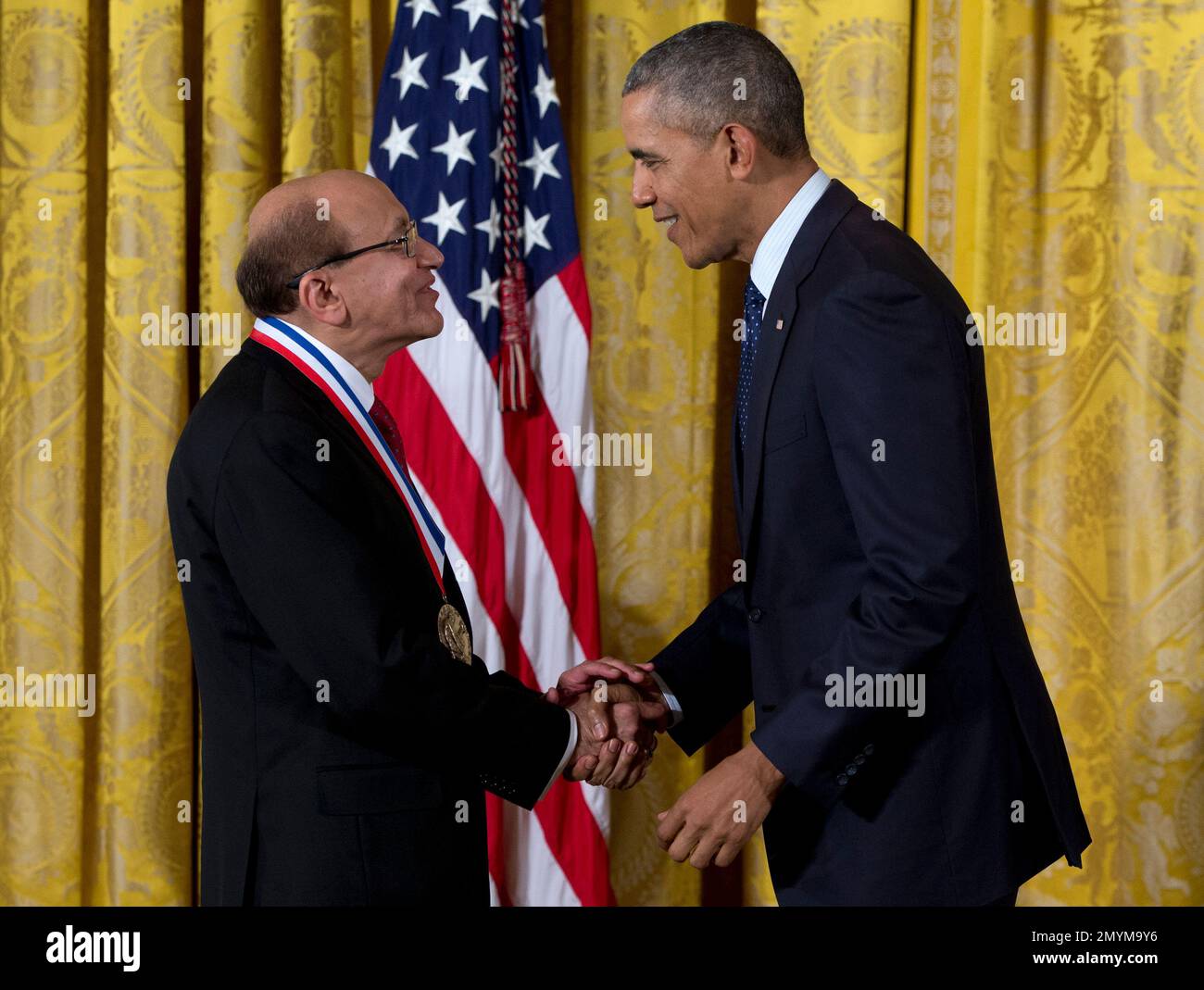 President Barack Obama shake hands with Dr. Rakesh K. Jain of Harvard