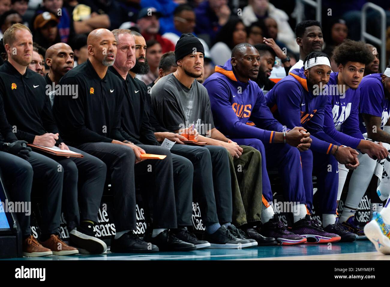 Phoenix Suns guard Devin Booker watches from the bench in street clothes in  the second half of an NBA basketball game against the Detroit Pistons in  Detroit, Saturday, Feb. 4, 2023. (AP
