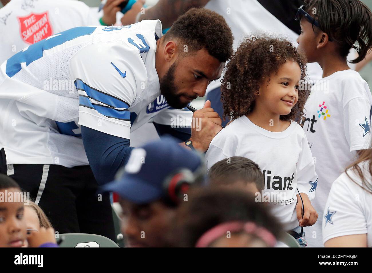 IMAGE DISTRIBUTED FOR RELIANT, AN NRG COMPANY - Dallas Cowboys rookie  running back Darius Jackson autographs a fan's shirt during the Reliant  Home Run Derby at the Dr Pepper Ballpark on Tuesday