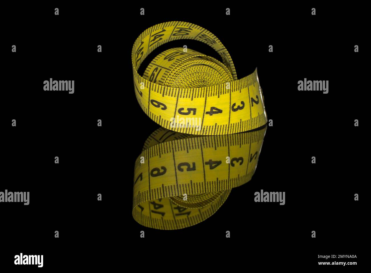 Premium Photo  Yellow measuring tape on a black background. slim waist  concept. close-up. shallow depth of field.