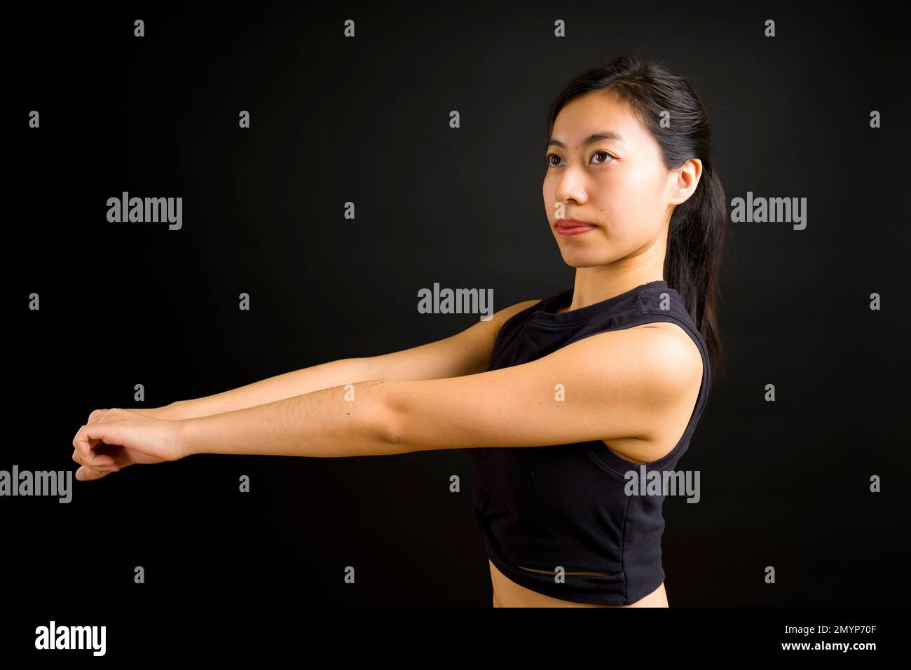 1/2 Body Side View of Beautiful Young Asian Dancer Woman with Arms Held Out in Front Stock Photo