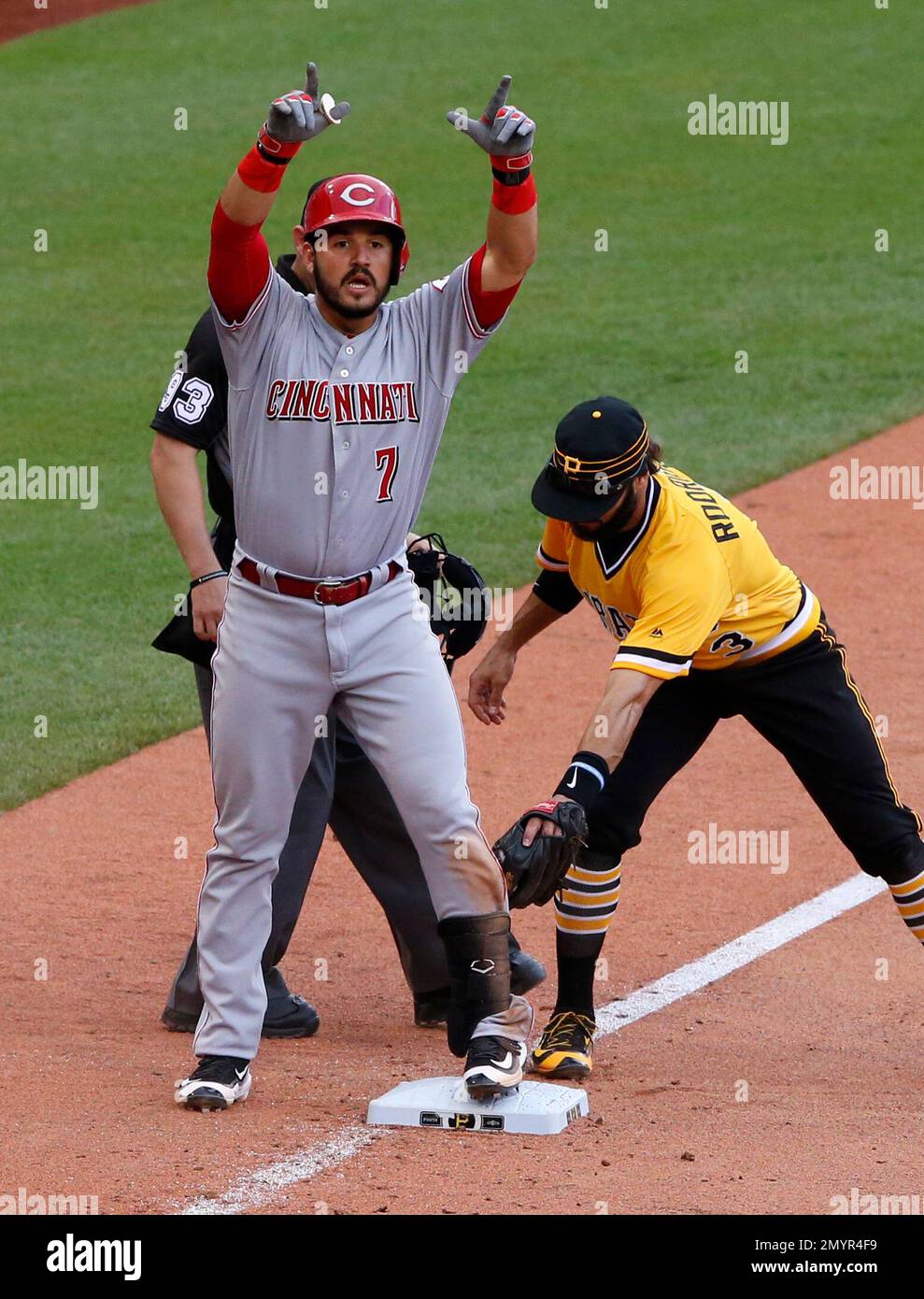 Cincinnati Reds' Eugenio Suarez (7) stands on third base with a triple as  Pittsburgh Pirates third baseman Sean Rodriguez, right, holds the late tag  during the eleventh inning of a baseball game