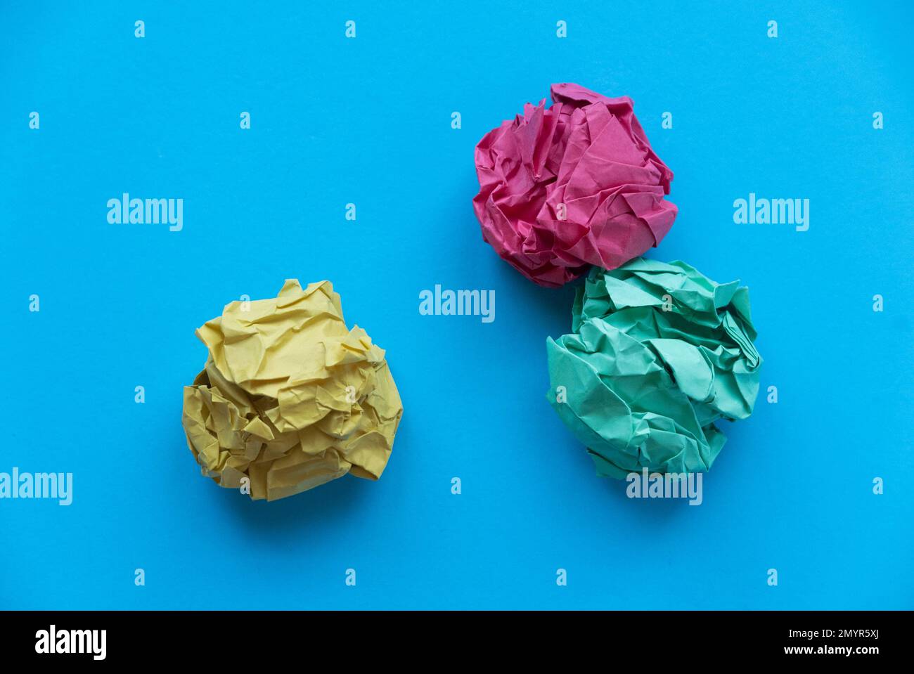 A colorful crumpled paper balls on a blue background. Stock Photo