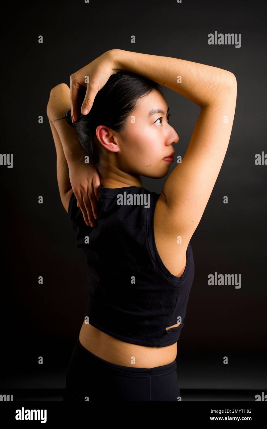 1/2 Body Back View of Young Asian Woman | Face in Profile with Arms Framing Head Looking Upwards Stock Photo