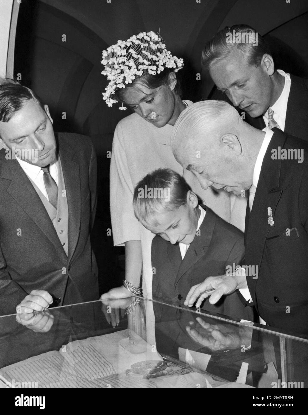 Prince Friedrich of Hohenzollern-Sigmaringen, right, shows old family documents to his son, Prince Johann Georg of Hohenzollern-Sigmaringen and his wife, Princess Birgitta of Sweden, at the Hohenzollern castle near Hechingen, Germany, on July 22, 1961, during celebrations of the 900th anniversary of the Hohenzollern family. The boy is Count Josef of Waldburg Zu Wolfegg. (AP Photo) Stock Photo