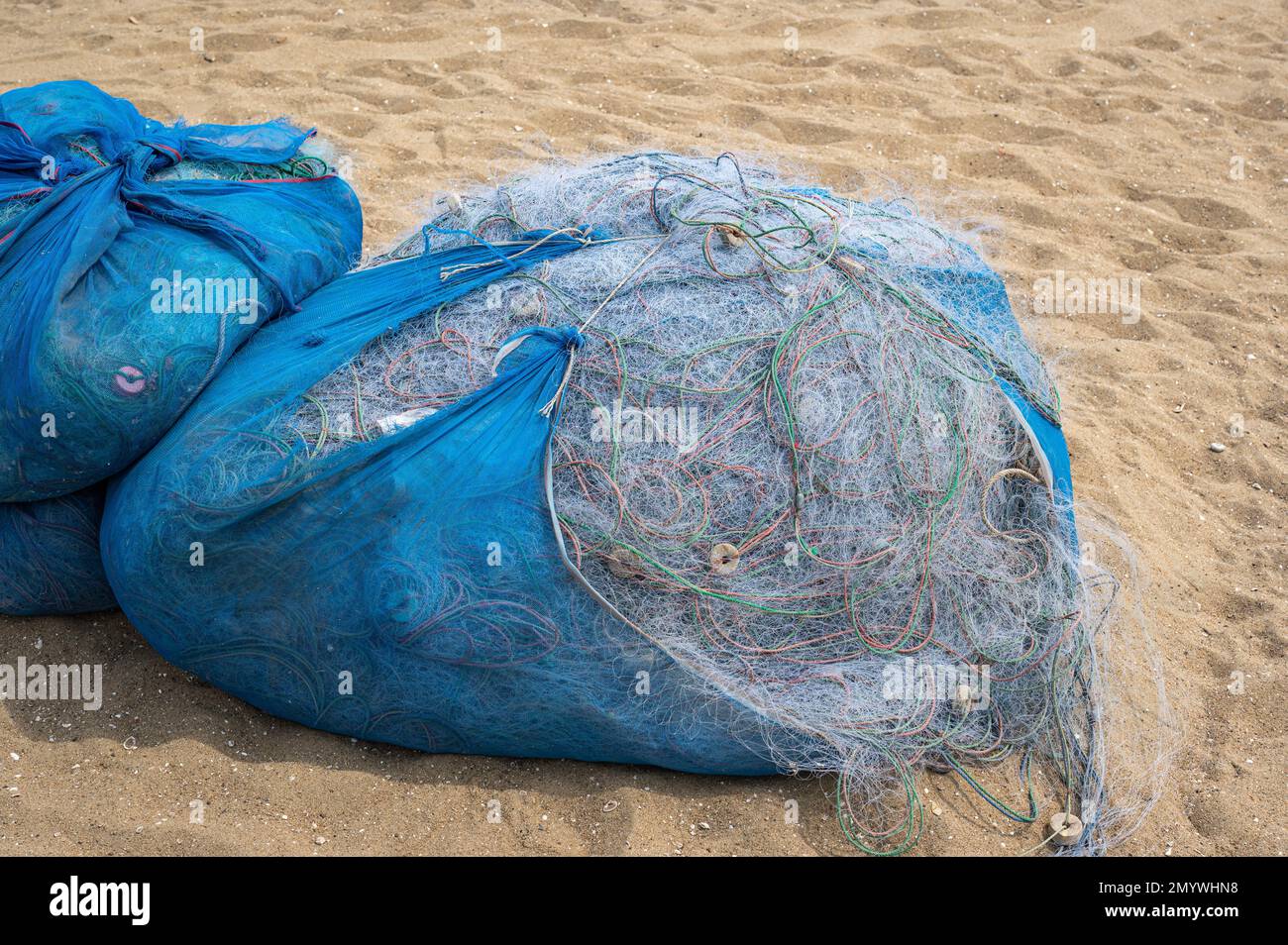 Fishing nets collected on sand beach. big bale of fishing nets