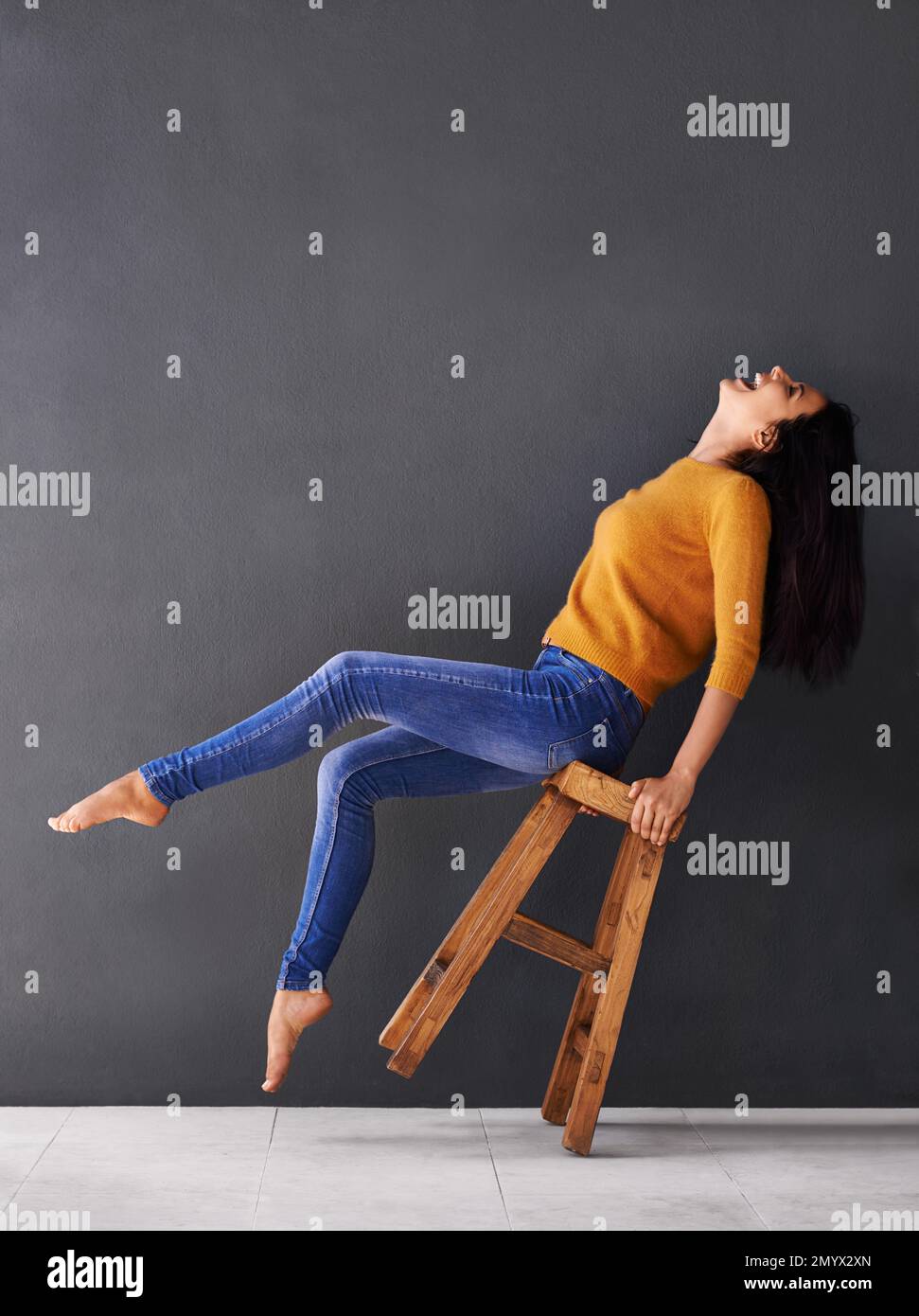 Throw your head back laughing. a happy young woman laughing while