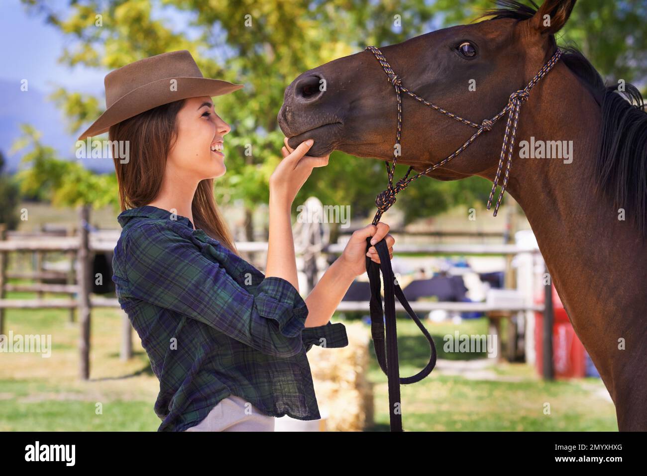 Easy girl. a young cowgirl standing outside with her horse. Stock Photo