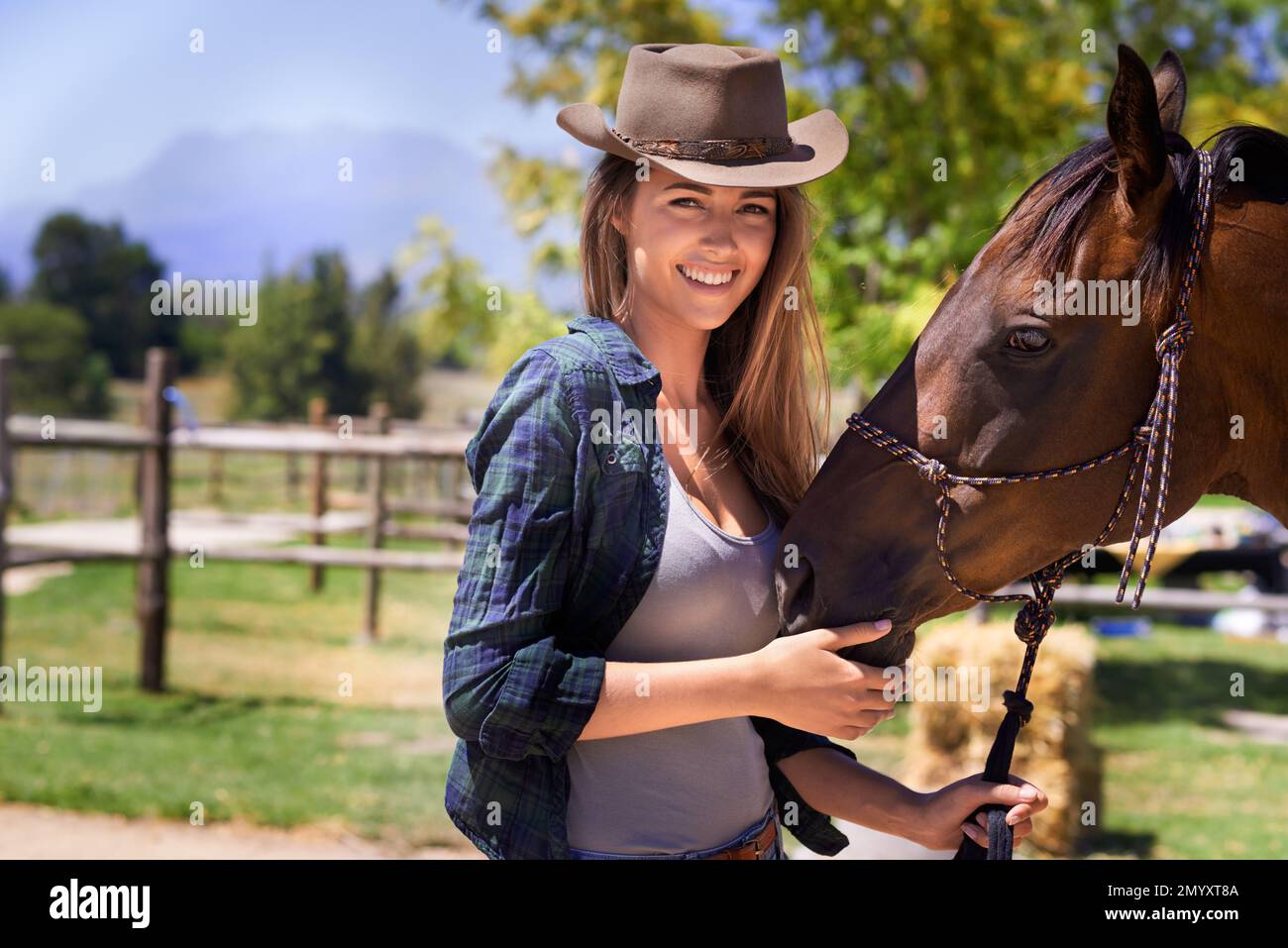 Cowboy Up or go sit in the Truck. Portrait of a young cowgirl standing outside with her horse. Stock Photo