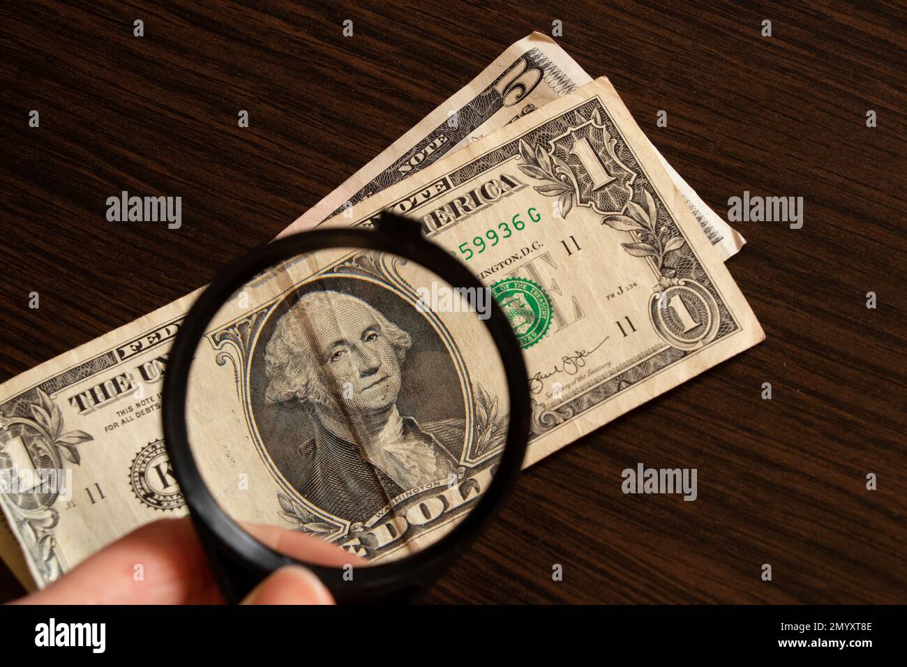 dollars and magnifying glass on the table, financial debt Stock Photo
