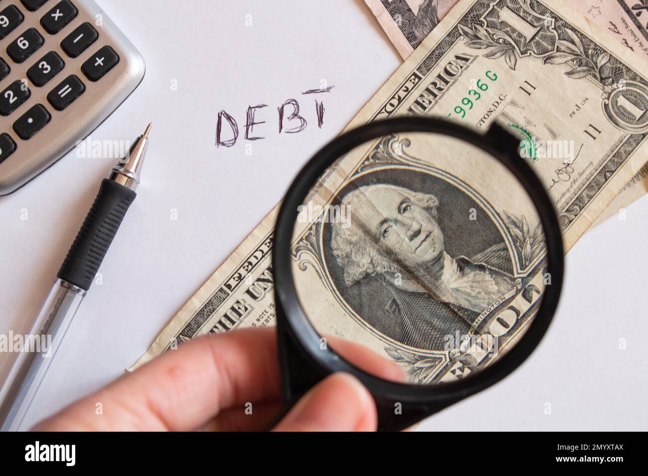 dollars and magnifying glass on the table, financial debt Stock Photo