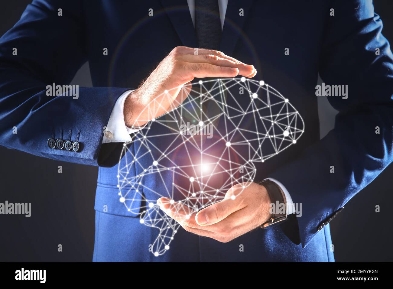 Businessman holding digital image of brain in hands on dark background, closeup. Machine learning concept Stock Photo