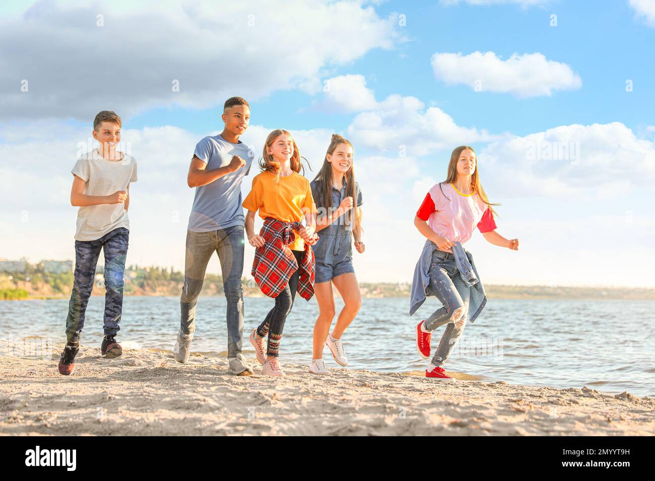 School holidays. Group of happy children running on beach Stock Photo