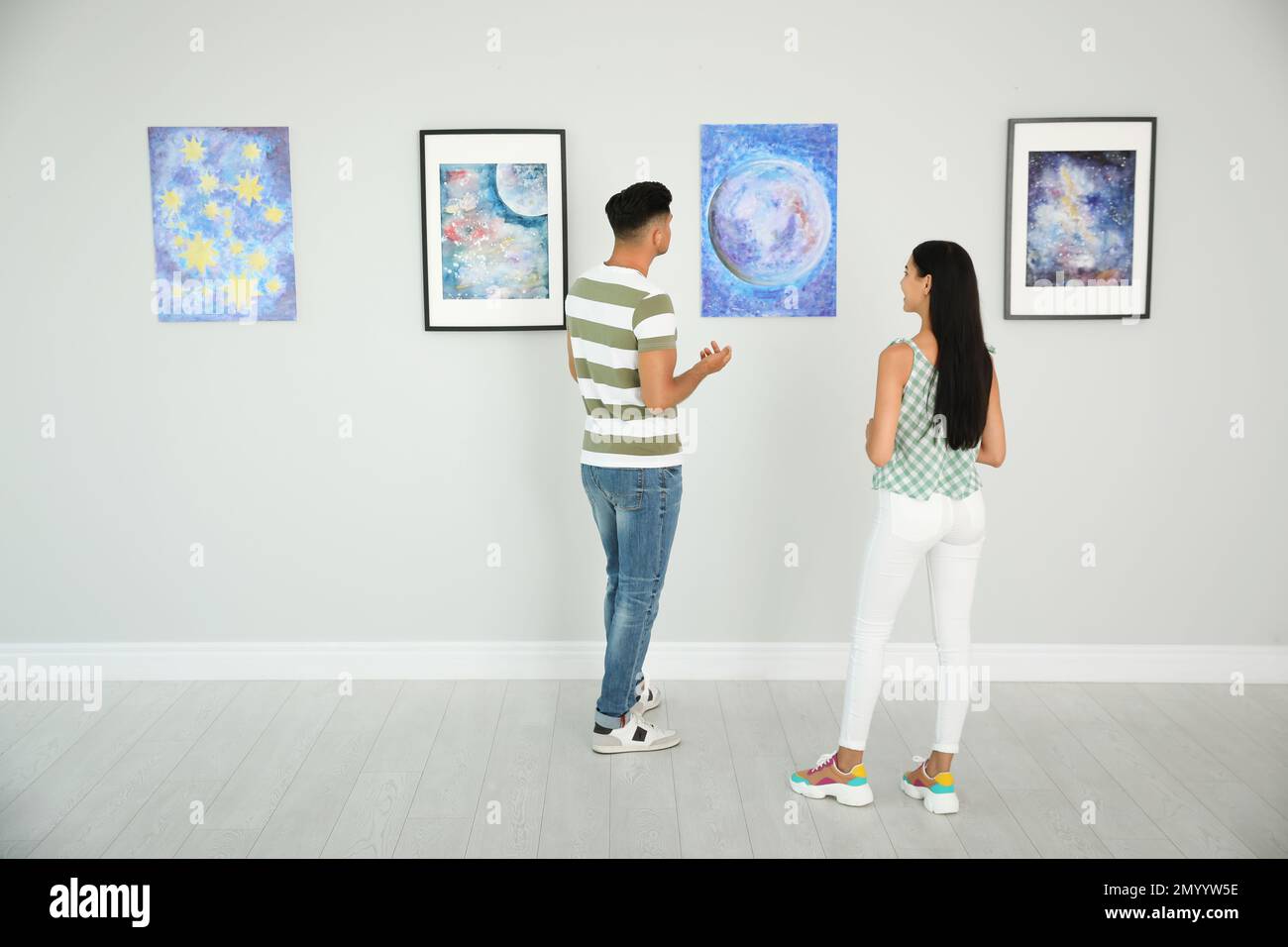 Man and woman at exhibition in art gallery Stock Photo - Alamy