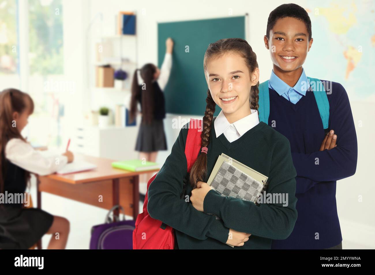 Happy teens with backpacks in school classroom Stock Photo Alamy
