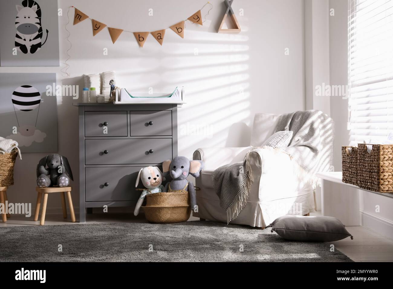 Chest of drawers with changing tray and pad in baby room. Interior